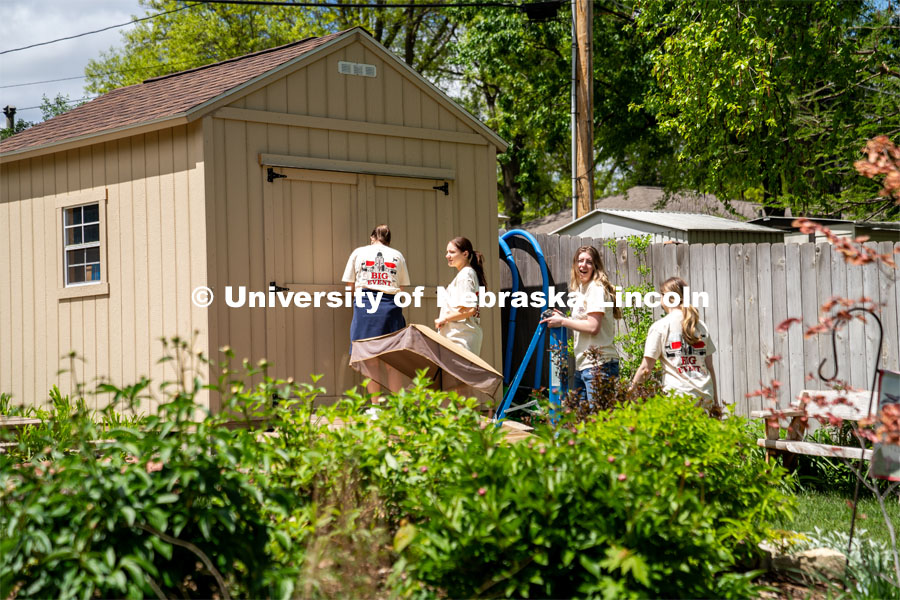 Members of Tri Delta, Sophie Helm, Alyssa Dunlap, Rachel Nelson, and Kate Freeman, go to a homeowner’s shed to put away tools that were provided to them during the Big Event. May 4, 2024. Photo by Kirk Rangel for University Communication.